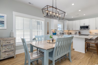 Dining area featuring light wood-style flooring, recessed lighting, and a chandelier