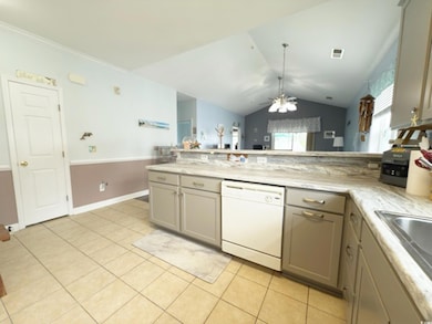 Kitchen featuring a ceiling fan, white dishwasher, light tile patterned floors, gray cabinetry, and a peninsula