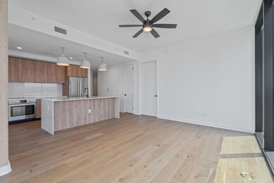 Kitchen featuring stainless steel appliances, modern cabinets, light countertops, brown cabinetry, and light wood-style flooring