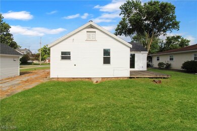 Back of property featuring a lawn and a deck