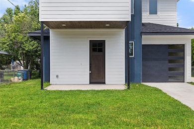 View of exterior entry with driveway, roof with s