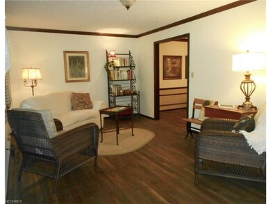 Living room is neutrally painted with hardwood flo