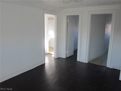 Unfurnished bedroom with dark hardwood / wood-style floors