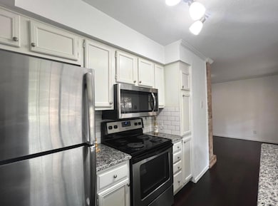 Kitchen featuring light stone counters, backsplash