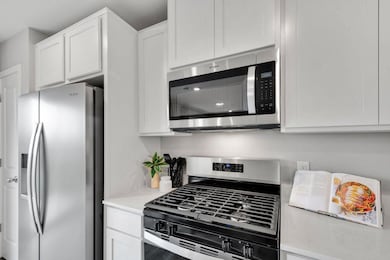 Stainless steel appliances and quartz countertops. Photo is of model home. Colors and options may vary. Ask Sales Agent for details.