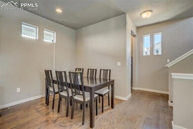 Dining space featuring a textured ceiling and wood-type flooring