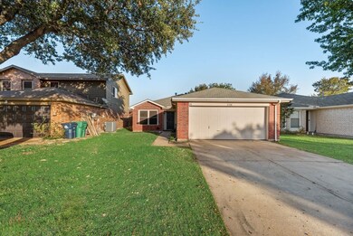 View of front of house with driveway, brick siding, and a front yard