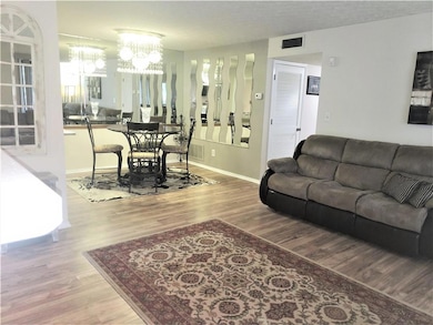 Living room featuring light wood-style floors and a chandelier