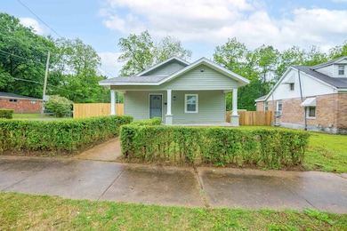 Bungalow-style house with covered porch and fence