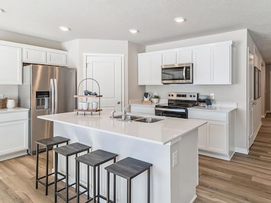 Modern white kitchen with quartz countertops and island.
