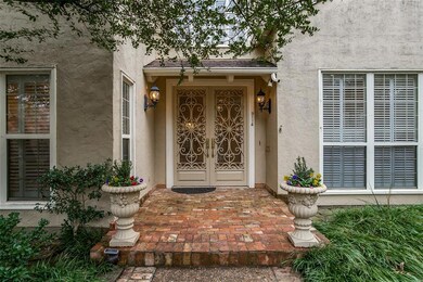 Covered entry, with custom doors, and large bricke
