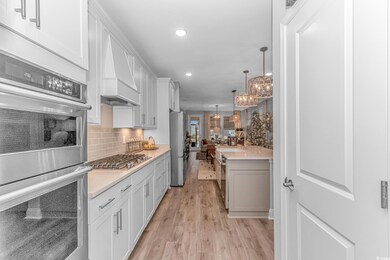 Kitchen with white cabinetry, light hardwood / woo