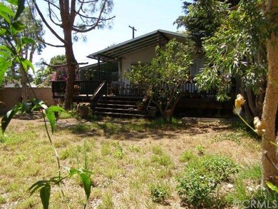 Spacious back yard with trees.