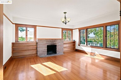 Unfurnished living room with wood finished floors, a fireplace with flush hearth, and a chandelier