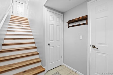 Stairway featuring tile patterned flooring and baseboards