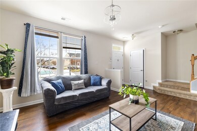 Living room with dark wood-type flooring and a cha