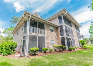 Rear view of property featuring a lawn, a sunroom,