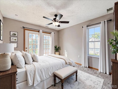 Digitally Staged Bedroom featuring a textured ceiling, light colored carpet, and ceiling fan