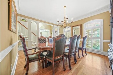 Dining area featuring a chandelier, light wood-style floors, ornamental molding, and stairs
