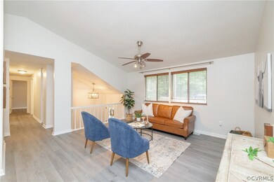 Living room with lofted ceiling, ceiling fan, and