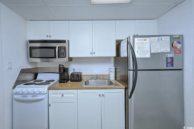 Kitchen featuring white cabinets, a drop ceiling, 