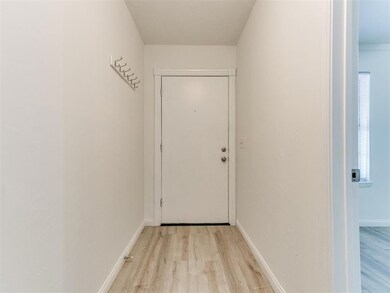 Doorway featuring baseboards and light wood finish