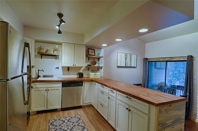 Kitchen featuring appliances with finishes, wooden