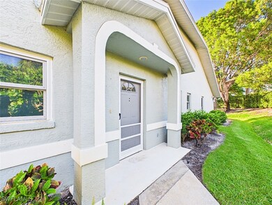 Property entrance with a lawn and stucco siding