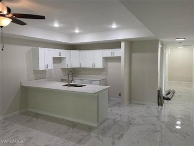 Kitchen featuring a peninsula, marble finish floor