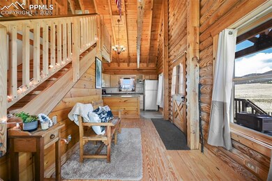 Living area with healthy amount of natural light, light wood-style floors, wooden ceiling, a chandelier, and wooden walls