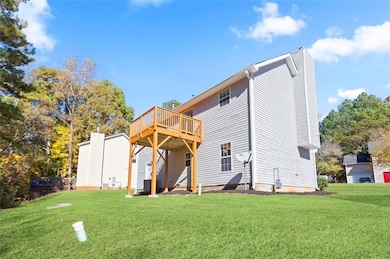 Back of house with a yard, a deck, and a chimney