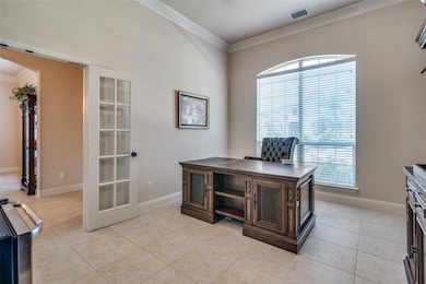 Office area featuring light tile flooring, french doors, and crown molding