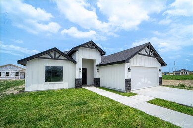 Modern farmhouse featuring board and batten siding, a front lawn, an attached garage, and driveway