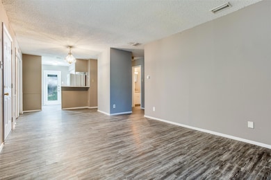 Unfurnished living room featuring a textured ceil