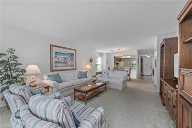 Living area with light carpet and a chandelier