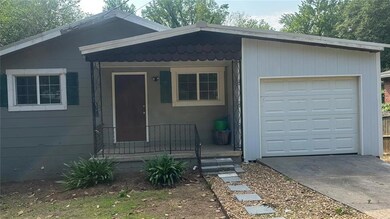 View of front of property with a garage and driveway
