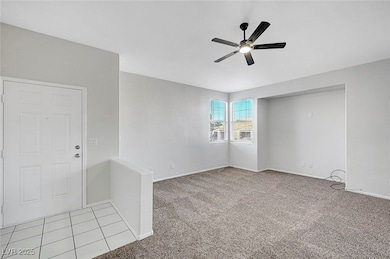 Carpeted empty room featuring a ceiling fan and ba