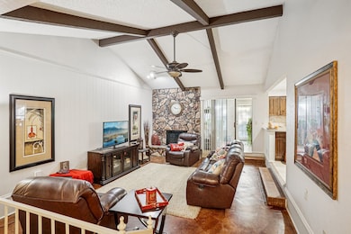 Living area featuring a fireplace and ceiling fan
