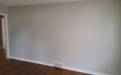 Empty room with dark hardwood / wood-style floors