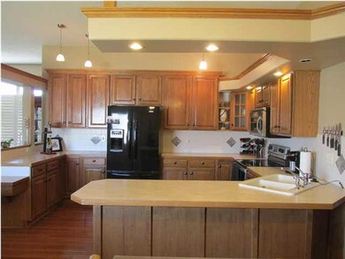 Spacious kitchen has hardwood floors.
