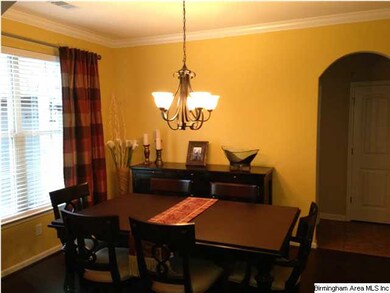 Dining room has arched entry, crown molding, chand