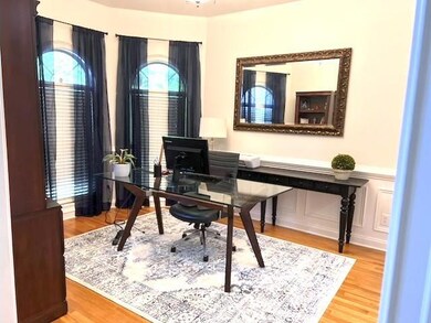 Office featuring wood finished floors, a wainscoted wall, and a decorative wall