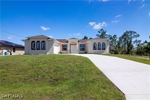 View of front of home with an attached garage, con