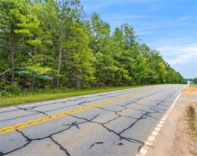 View of asphalt road featuring a wooded view