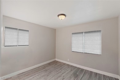 Empty room with baseboards and wood finished floors