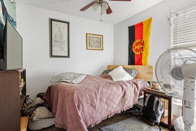 Bedroom featuring ceiling fan and a textured ceil