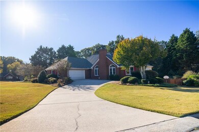 View of front of home featuring concrete driveway, a chimney, and a garage