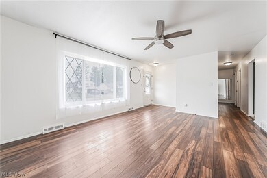 Unfurnished living room featuring dark hardwood / wood-style flooring and ceiling fan