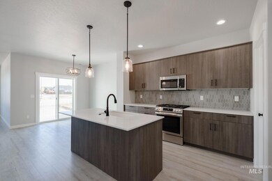Kitchen featuring stainless steel appliances, decorative light fixtures, light wood-style floors, tasteful backsplash, and recessed lighting