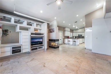 Living room with a multi sided fireplace, recessed lighting, and ceiling fan